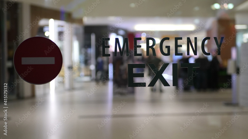 Fototapeta premium Emergency exit sign on empty city mall during pandemic