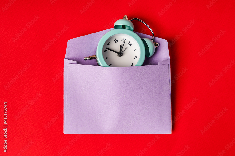 The alarm clock is on the envelope, conceptual background and minimalism The alarm clock is on the envelope, conceptual background and minimalism