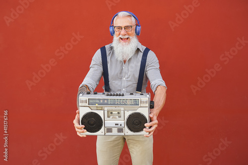 Bilde på lerret Happy senior man having fun listening to music with wireless headphones and vint