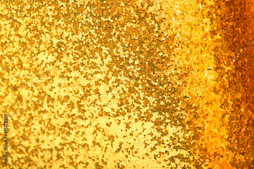 Shiny gold sequins background  bokeh sequins texture. Beautiful festive Christmas background for the design of congratulations. Sparkling pearl yellow texture. Gold surface with patterns.