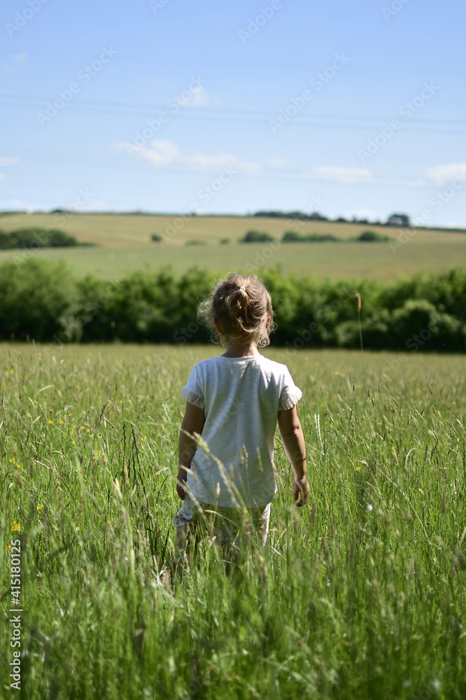 Child in field of long grass. 