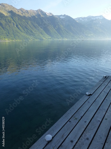 View over Brienzersee Lake on a tranquil late Spring morning with wooden jetty in the foreground