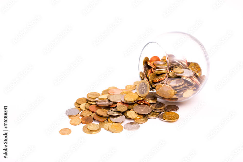 Glass jar with scattered coins on a light background. Accumulation and investment with increasing income. Save money on training in the future. Contribution to the future.