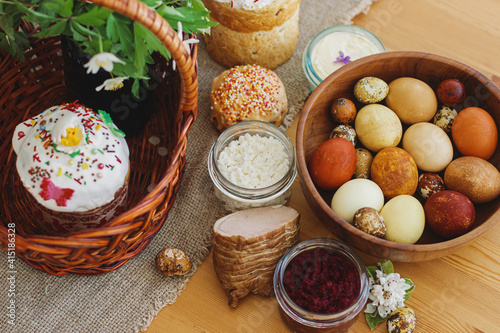 Traditional Easter food, homemade Easter bread,  easter eggs and spring flowers on rustic table