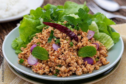 Laab gai or larb gai, spicy minced chicken breast salad, the healthy food served with fresh vegetables. This clean food in Isan Thai food style uses lean chicken meat that is good for diners’ health. photo