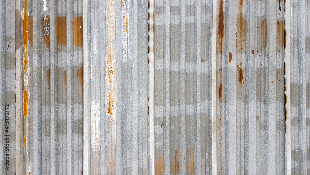 A rusty and weathered piece of corrugated metal. Corroded galvanized iron sheet. old zinc wall background. A rusty and weathered piece of corrugated metal. Corroded galvanized iron sheet. old zinc wall background.
