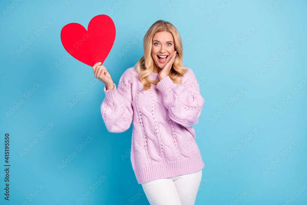 Photo portrait of blonde woman showing heart love symbol touching cheek overjoyed isolated bright blue color background Photo portrait of blonde woman showing heart love symbol touching cheek overjoyed isolated bright blue color background