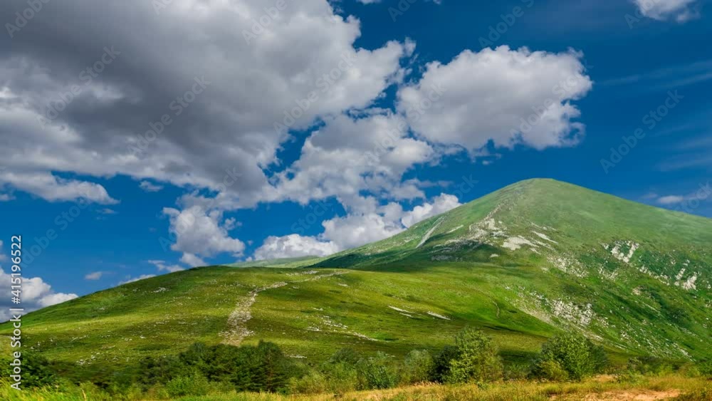 green mount top under a blue cloudy sky, travel time lapse scene