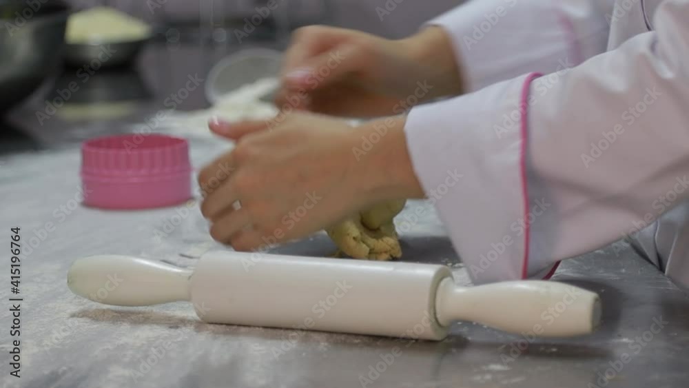 woman's hands kneading flour to make cookies