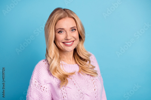 Photo portrait of blonde wavy hair woman smiling wearing fashionable outfit isolated vibrant blue color background © deagreez
