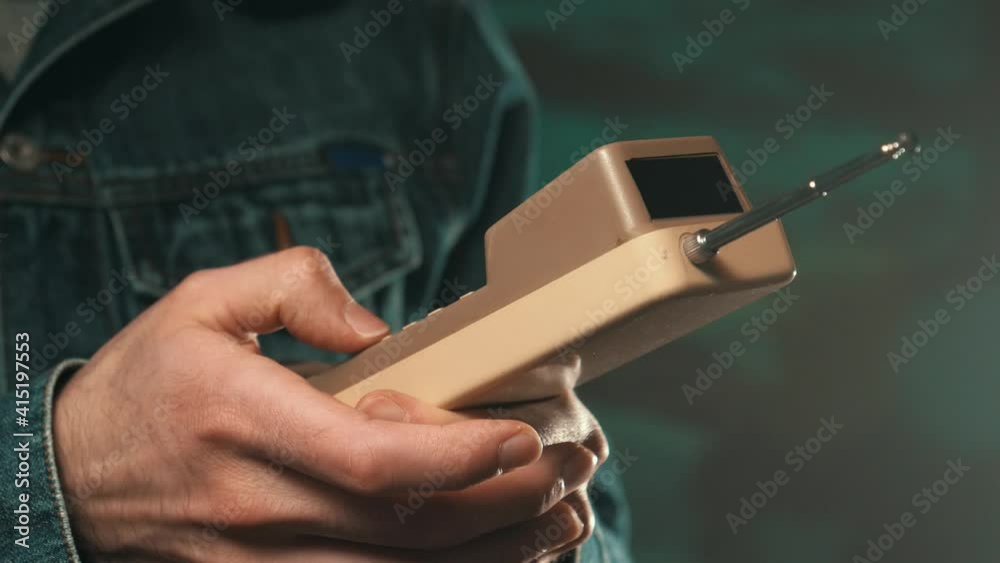 Dialling a phone number using a retro vintage brick cellphone. 80s 90s concept shot