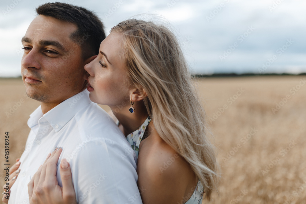 Obraz premium Young loving couple gently hugging on the background of wheate fild. Love Story.