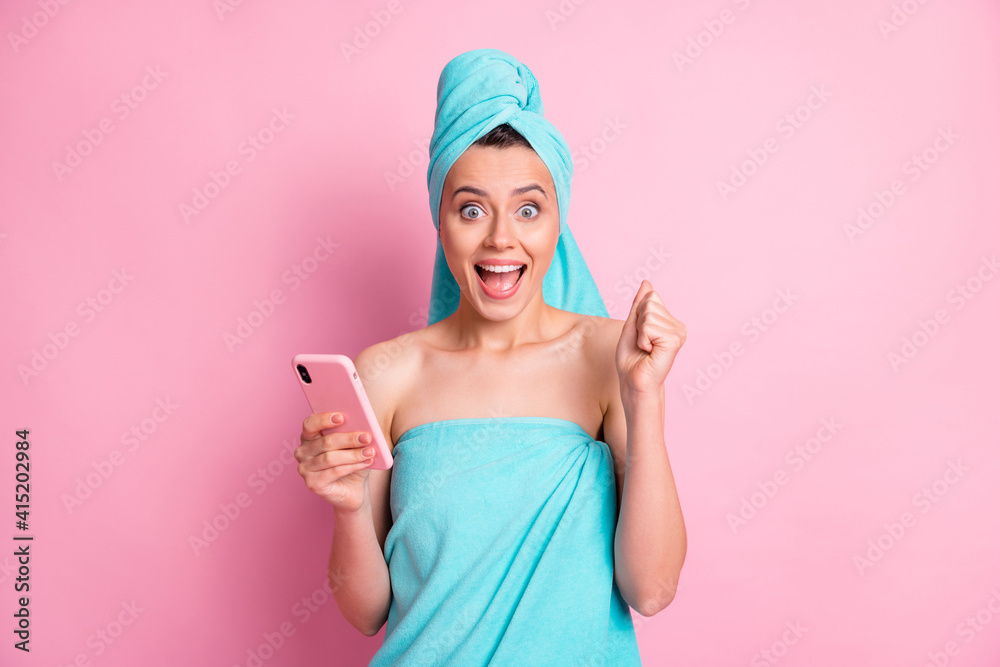 Portrait of hooray nice young lady hold telephone hand fist wear teal towels isolated on pastel pink color background Portrait of hooray nice young lady hold telephone hand fist wear teal towels isolated on pastel pink color background