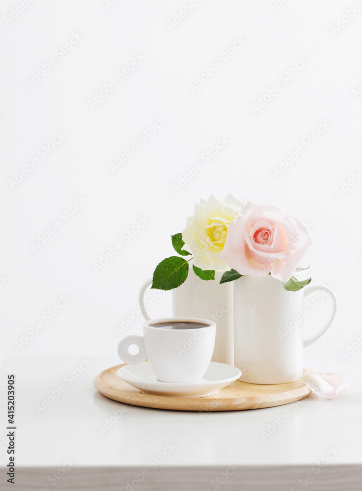 two roses in cups with cup of coffee