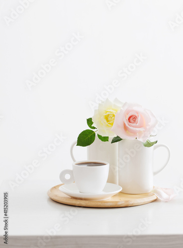 two roses in cups with cup of coffee