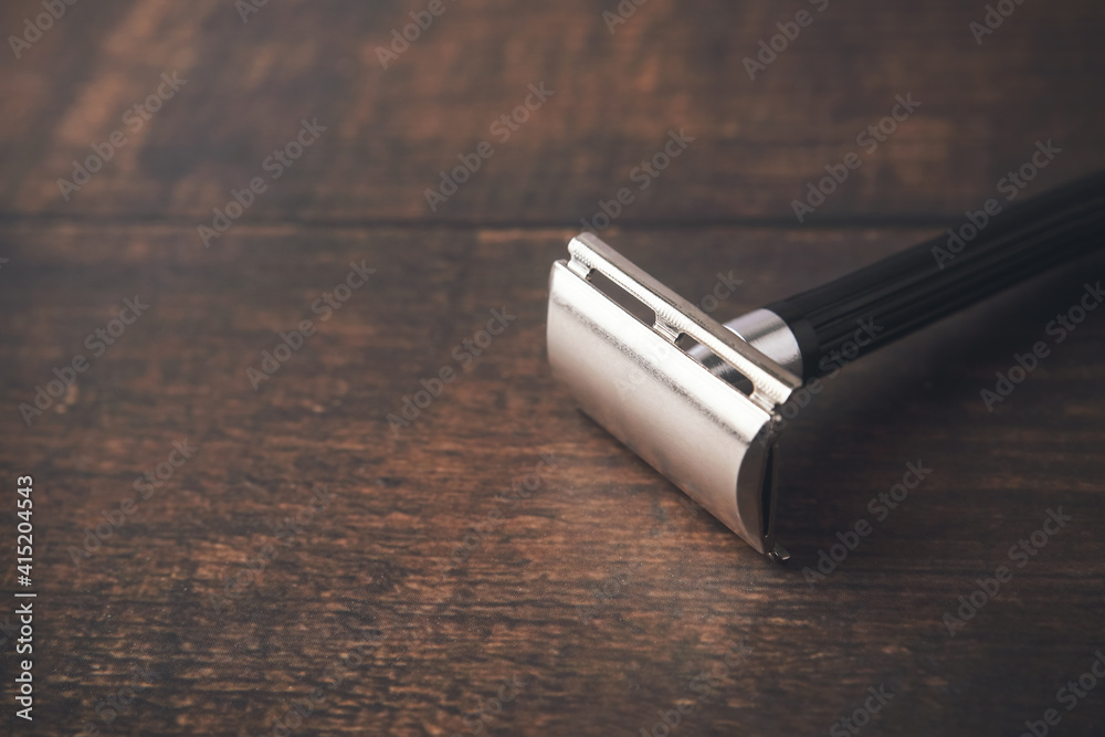 Stainless steel razor on wooden table Stainless steel razor on wooden table