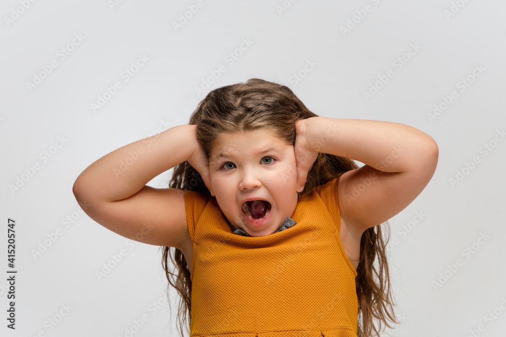 Scared. Happy, smiley little caucasian girl isolated on white studio background with copyspace for ad. Looks happy, cheerful. Childhood, education, human emotions, facial expression concept. Scared. Happy, smiley little caucasian girl isolated on white studio background with copyspace for ad. Looks happy, cheerful. Childhood, education, human emotions, facial expression concept.