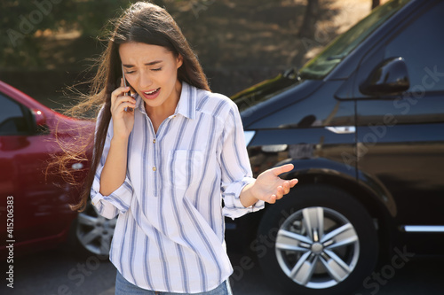 Stressed woman talking on phone after car accident outdoors © New Africa