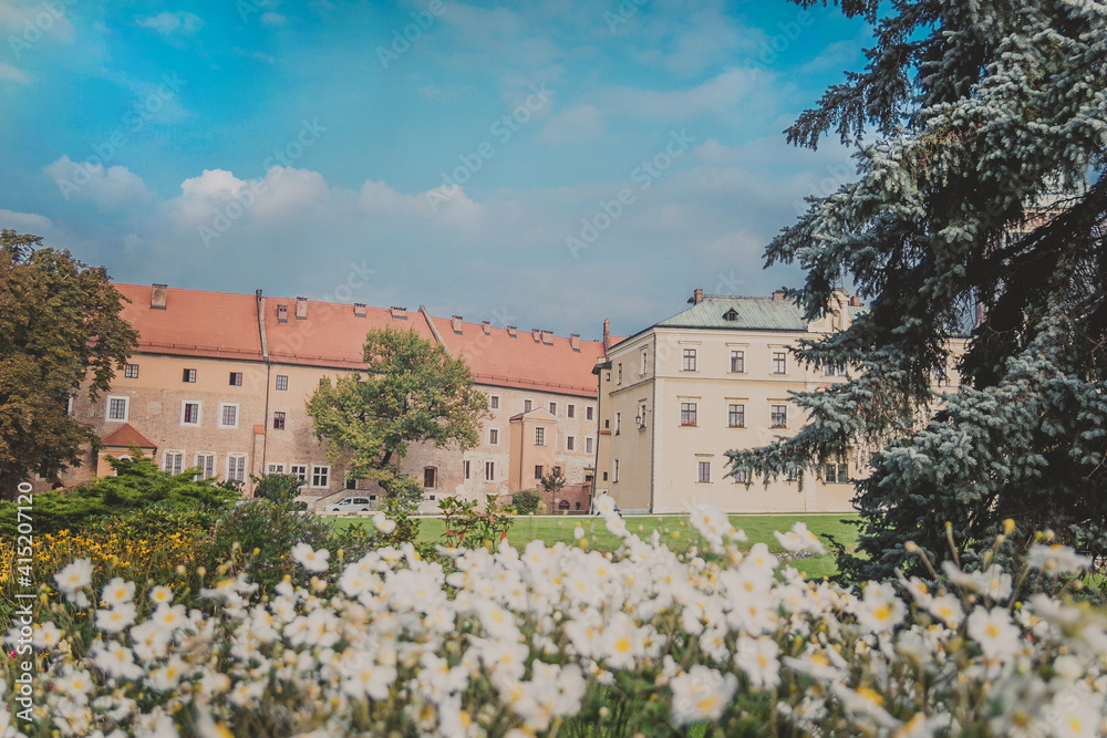 View of Cathedral museum, Vicar's House, green lawns, trees, flowers and bushes on Wawel Hill known as the Wawel Cathedral in Krakow Royal Castle on sunny day. One of most popular landmarks in Poland
