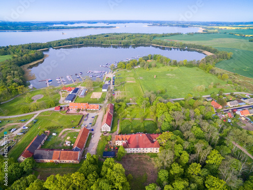 Ruined Baroque style palace in Sztynort, Poland (former Steinort, East Prussia). Sztynorckie Lake and yachts moored in marina in the background photo