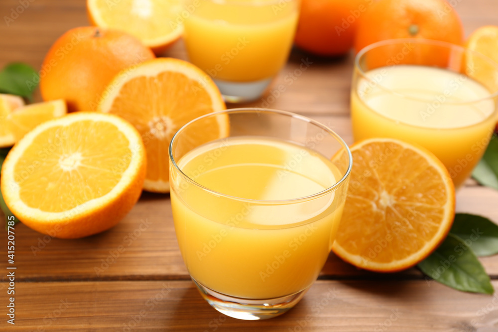Delicious orange juice and fresh fruits on wooden table, closeup Delicious orange juice and fresh fruits on wooden table, closeup