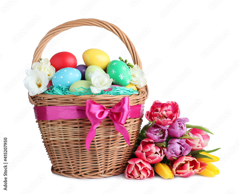 Wicker basket with bright painted Easter eggs and spring flowers on white background Wicker basket with bright painted Easter eggs and spring flowers on white background