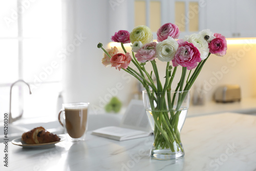 Wallpaper Mural Beautiful fresh ranunculus flowers near cup of coffee, croissant and book on table in kitchen Torontodigital.ca