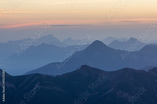 blue hour mountain range layers at sunrise in the swiss alps