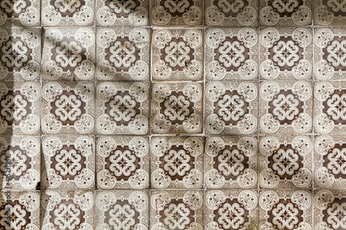 sunlight casting a shadow on brown white pattern painted tiles
