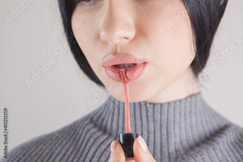 beautiful girl paints her lips