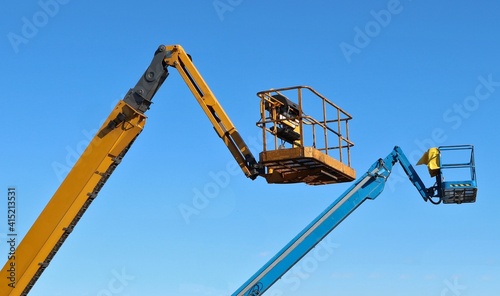 Wallpaper Mural Two cherry picker buckets against blue sky. Torontodigital.ca