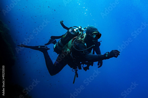 Scuba diver swimming in deep blue photo