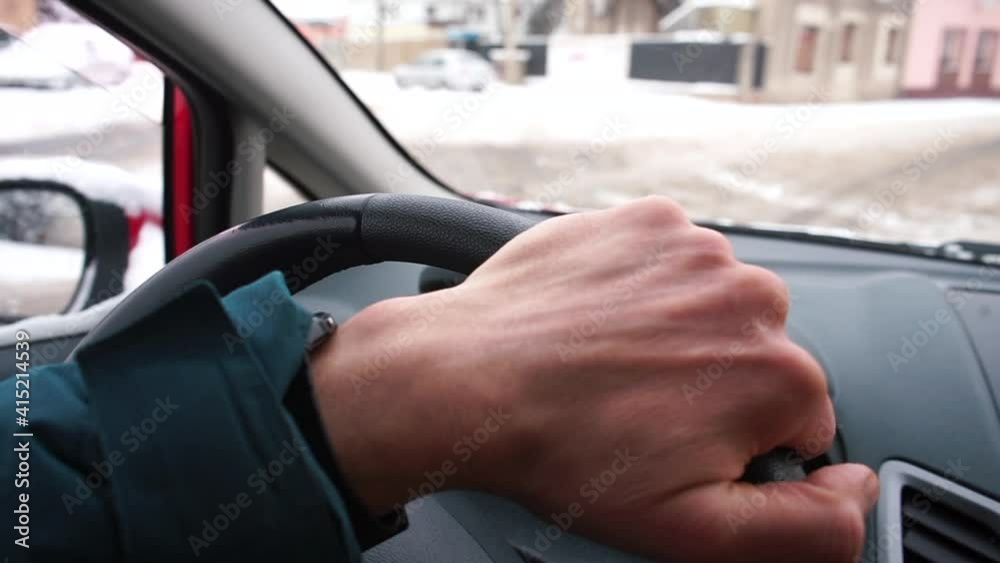 The driver's hand touches the steering wheel while driving a car in the city. Management of vehicles in winter. Compliance with traffic rules. The driver's hand touches the steering wheel while driving a car in the city. Management of vehicles in winter. Compliance with traffic rules.