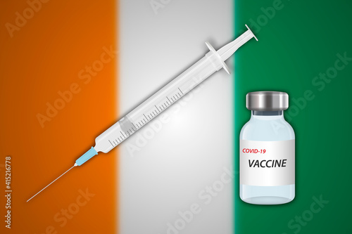Syringe and vaccine vial on blur background with Ivory Coast flag,