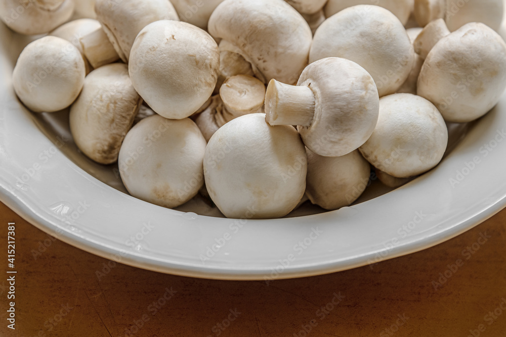 fresh raw champignons on white plate close up fresh raw champignons on white plate close up