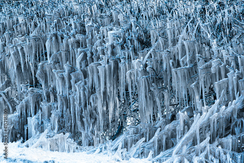 UK weather with icicles formed from splashed road water