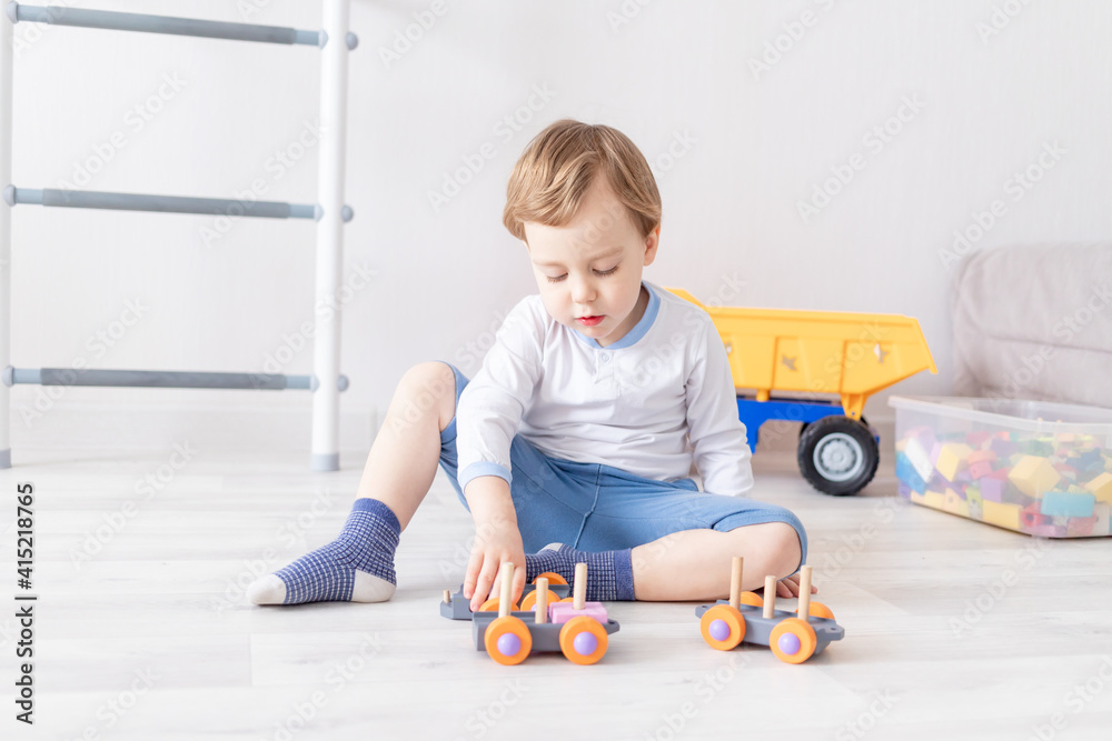 baby boy playing with wooden toys at home on the floor Stock Photo ...