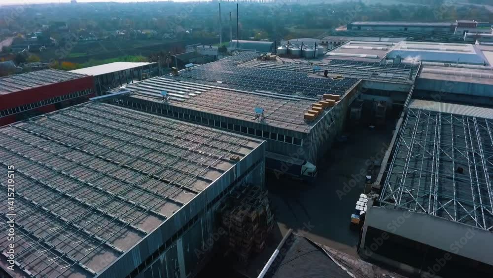 Construction of solar panels on industrial houses. Buildings with future solar panels on roof. Renewable energy from the sun. Construction of solar panels on industrial houses. Buildings with future solar panels on roof. Renewable energy from the sun.