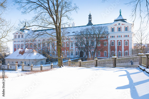 BROUMOV, CZECH REPUBLIC - FEBRUARY 10, 2020: View on famous benedictine monastery of Broumov and the broumov walls in the background. Broumov, Hradec Kralove, Czech Republic. Beautiful winter day