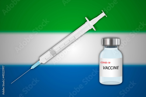Syringe and vaccine vial on blur background with Sierra Leone flag,