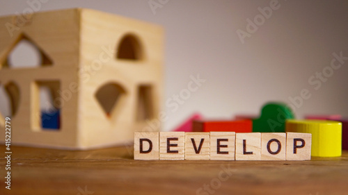 Selective Focus on DEVELOP word against children colourful learning toys