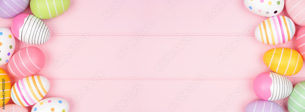 Colorful Easter Egg double border over a soft pink wood banner background. Above view with copy space.