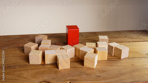 Wooden block surrounding red block. Leadership, teamwork concept.