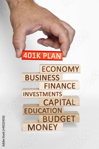 Businessman hand sets on a tower with business words red wooden block with the inscription - 401K PLAN photo