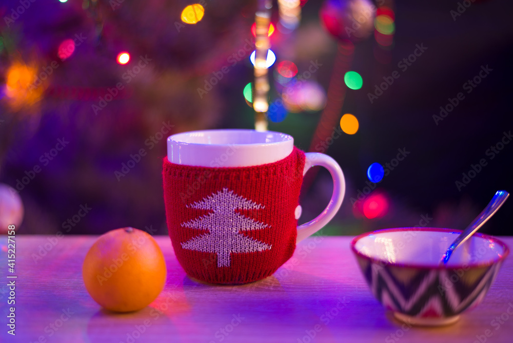 Fototapeta premium big red mug on the background of the Christmas tree