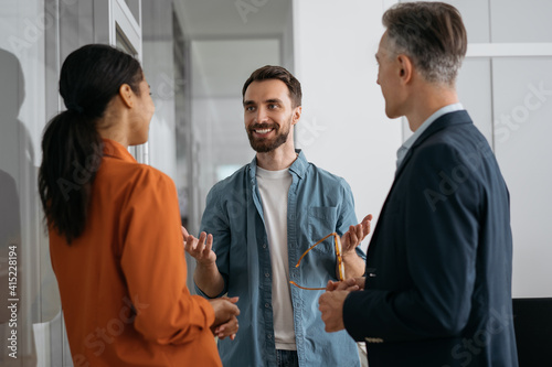 Business people talking, planning start up, having meeting in modern office. Portrait of successful man developer communication with colleagues. Teamwork, brainstorming concept 