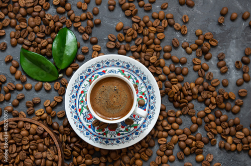 Turkish coffee concept, cup of coffee with coffee beans on dark stone background © mescioglu