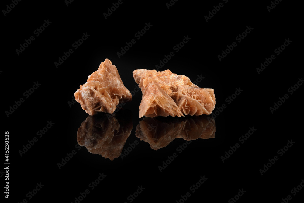 Gypsum desert rose from Tunisia on a black glass background. Gypsum desert rose from Tunisia on a black glass background.