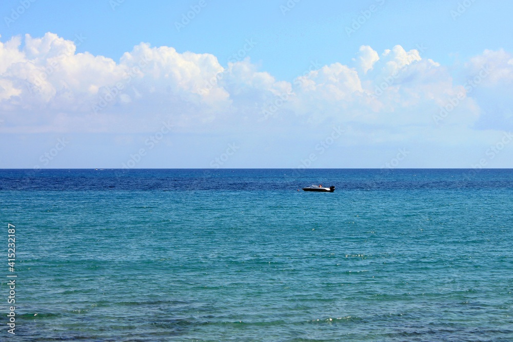 A view of the Mediterranean Sea near Crete and a small boat in the middle of the photo.
