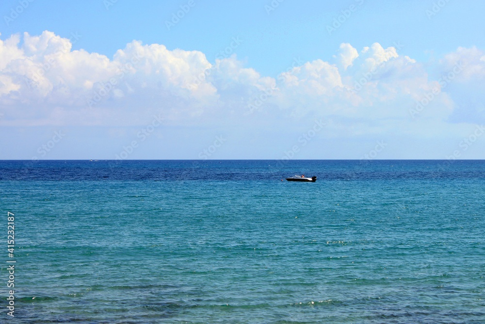 A view of the Mediterranean Sea near Crete and a small boat in the middle of the photo. A view of the Mediterranean Sea near Crete and a small boat in the middle of the photo.
